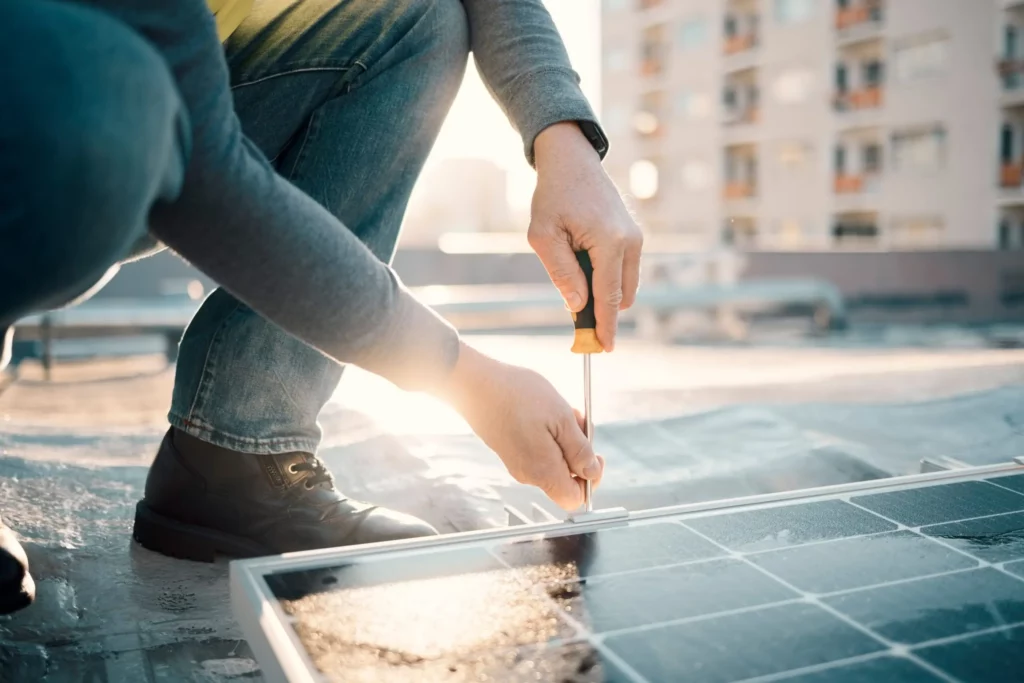 Photo d'une personne vissant un panneau solaire